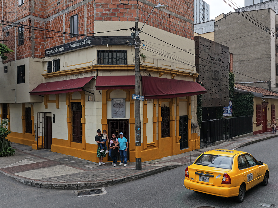 Exterior view of the Casa Cultural del Tango Homero Manzi in downtown Medellin, featuring the traditional architecture and the founding family at the entrance.